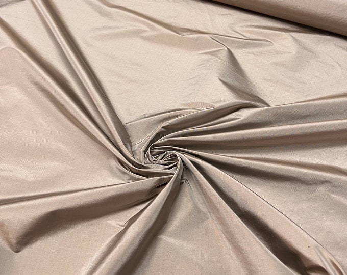 Beautiful Taupe Tan Irredescent 100% silk taffeta 54” wide.  Best used for apparel and home Decore.  Sold by the yard