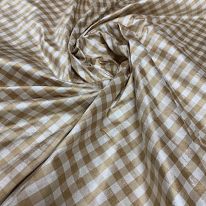 Beautiful taffeta tan and ivory gingham check 54” wide.  Best used for apparel and home Decore.  Sold by the yard