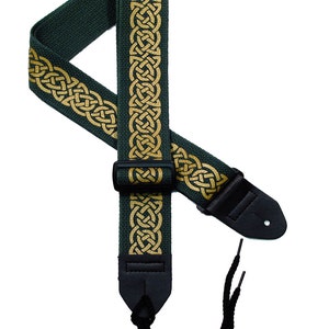 May include: A dark green guitar strap with a gold Celtic knot design. The strap has adjustable length and a black leather end.