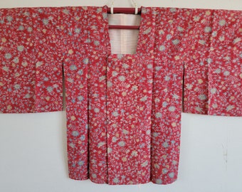 May include: A red and blue floral patterned Japanese kimono with a button closure.