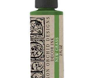 May include: A rectangular bottle of Iron Orchid Designs decor ink in the color New Grass. The label features a tan background with black decorative lettering and a black screw-top cap. The text reads Iron Orchid Designs Decor Ink New Grass 2 fl oz.