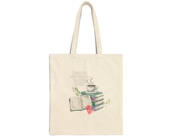 Puede incluir: Un bolso de tela beige con una ilustración impresa de una pila de libros, un libro abierto, una taza de café humeante y pequeñas flores. El texto "There's no such thing as too many books!" está impreso en una fuente clara sobre los libros.