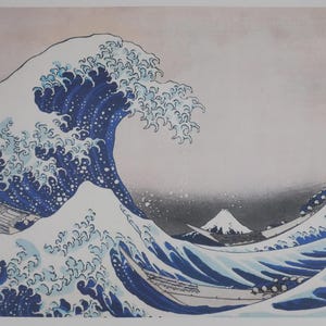 Puede incluir: Una impresión de "La gran ola de Kanagawa" de Hokusai. La obra representa una gran ola oceánica con espuma blanca rompiendo sobre un barco. El fondo muestra el monte Fuji bajo un cielo nublado. Texto japonés visible.