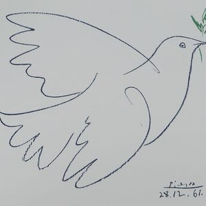 May include: A line drawing of a dove with outstretched wings, holding a green olive branch in its beak. The artwork is signed "Picasso" with the date "28.12.61" in the lower right corner. The dove is depicted in black on a white background.