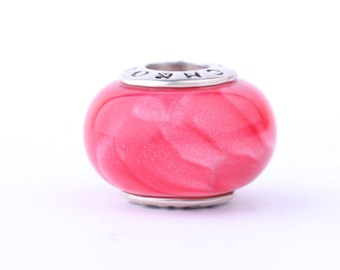 May include: A pink glass bead with a silver charm. The bead has a swirl pattern and a shiny finish.