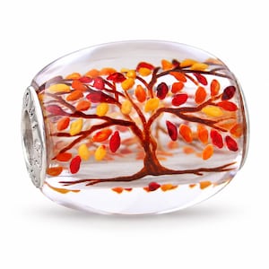 Può includere: Una perla in vetro trasparente a forma di barilotto con un albero dipinto all'interno caratterizzato da foglie vivaci nei toni del rosso, arancione e giallo. La perla presenta un nucleo in metallo argentato lucido con un motivo in rilievo.