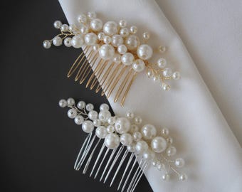 Puede incluir: Dos peines de pelo de perlas, uno con un peine dorado y otro con un peine plateado. Ambos peines están decorados con racimos de perlas y alambre.