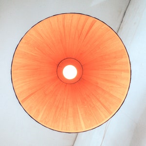 Warm light glowing through maple veneer pendant lamp creating cozy ambient lighting