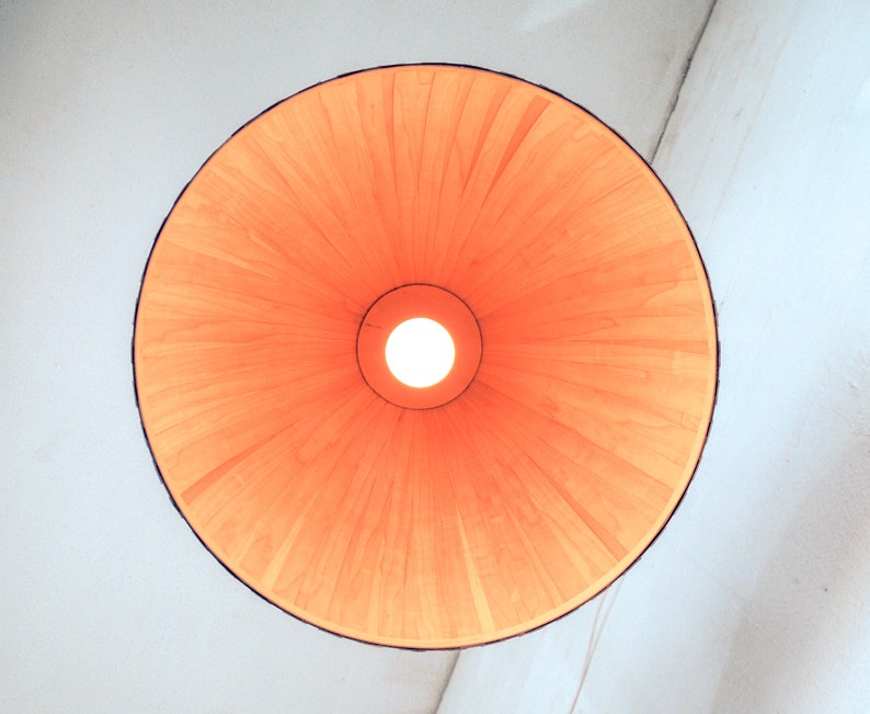 Warm light glowing through maple veneer pendant lamp creating cozy ambient lighting