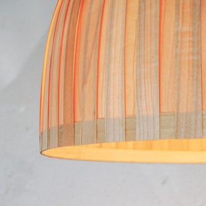 Warm light glowing through maple veneer pendant lamp creating cozy ambient lighting