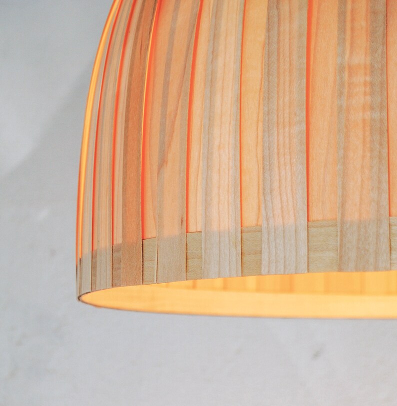 Warm light glowing through maple veneer pendant lamp creating cozy ambient lighting