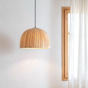 Warm light glowing through maple veneer pendant lamp creating cozy ambient lighting