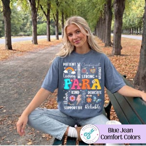 May include: A blue jean colored short-sleeve t-shirt featuring a graphic print with the word PARA in large colorful letters surrounded by smaller words including Patient, Loving, Strong, Kind, Dedicate, Supportive, and Reliable with icons.
