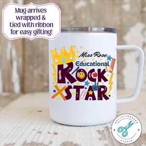 May include: White travel mug with a handle, featuring the text "Miss Rose Educational Rock Star" in colourful letters and graphics. A gold crown and stars decorate the design. The mug has a silver lid.