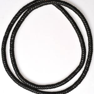 May include: A black braided cord necklace made of small, flat, rectangular beads. The cord is doubled and twisted to create a braided effect.