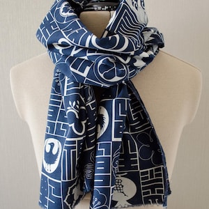 日本の伝統的な模様、漢字のロゴ、アイコンがプリントされたパッチワークスカーフ。ネイビーブルーの背景に白、波型のステッチの縁取り。