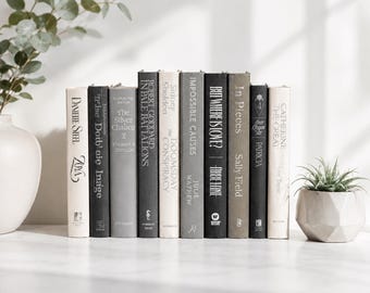 May include: A collection of ten hardcover books arranged vertically in a row, featuring spines in shades of cream, gray, and black. The titles include Zoya, The Silver Chalice, In Pale Battalions, The Doomsday Conspiracy, Impossible Causes, and In Pieces.