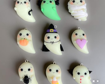 May include: Nine glow-in-the-dark Halloween-themed ghost charms. The charms are made of polymer clay and feature different designs, including a cat, a mummy, a witch, a vampire, a spider, a pumpkin, a heart, a candy corn, and a Frankenstein.