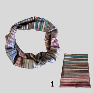 May include: A multi-colored striped knit infinity scarf and matching skirt. The scarf is a loop of fabric with horizontal stripes in shades of blue, green, brown, and pink. The skirt has a similar striped pattern.