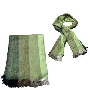 May include: A rectangular throw blanket and a matching scarf featuring a vertical striped pattern in various shades of green, ranging from dark forest green to light lime green, with fringed edges on both items in coordinating colors.