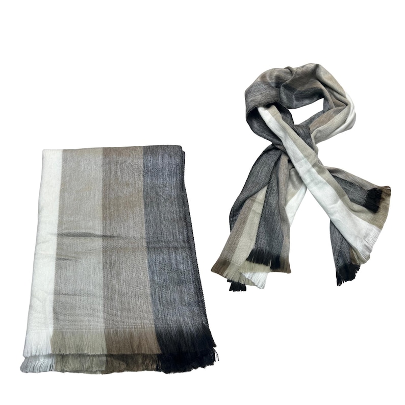 May include: A rectangular throw blanket and a matching scarf featuring a vertical striped pattern in shades of white, beige, light brown, dark gray, and black. Both items have a soft, textured appearance and include fringed edges at the ends.