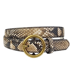 Pode incluir: Um cinto com padrão de pele de cobra com uma fivela circular dourada. O cinto apresenta um padrão repetido de escamas castanhas, bege e pretas. O cinto tem aproximadamente 2,5 cm de largura.