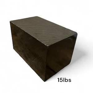 May include: A dark, rectangular block with a glossy finish. The block is labeled with "15lbs" on the bottom right. The object appears to be made of wood or a similar material.