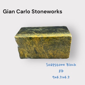 Peut inclure: Un bloc de stéatite rectangulaire à surface rugueuse et texturée. La pierre est principalement jaune avec des veines vert foncé et noires. Le bloc pèse 8 lb et mesure 22,86 x 11,43 x 11,43 cm. Le texte "Gian Carlo Stoneworks" est en haut.