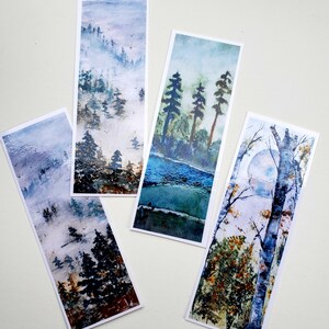 May include: Four rectangular bookmarks with watercolor landscape paintings. The designs feature misty forests, a river scene, and a moonlit birch tree. Each bookmark has a white border and showcases a different nature scene.