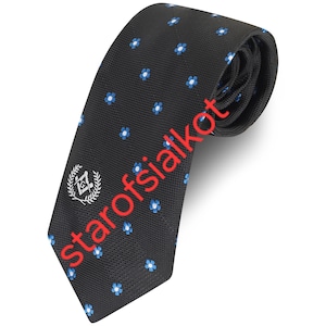 May include: Black necktie with a repeating pattern of small blue and white flowers. The tie features a Masonic emblem and the text "starofsialkot" in red. The tie is made of a textured fabric.