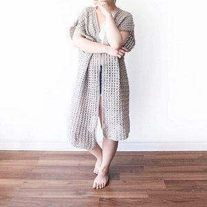 Puede incluir: Un c&aacute;rdigan largo de crochet de punto abierto en color beige claro. El c&aacute;rdigan tiene un corte holgado y presenta un patr&oacute;n de punto simple y abierto.