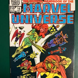 May include: Marvel Comics Group's "The Official Handbook of the Marvel Universe" comic book, issue 14. The cover features various superheroes in action, with the title in large blue letters. The comic has a white background with the price and issue number.