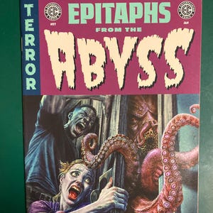 May include: A white ceramic mug with a black handle and the text "But First, Coffee" in a handwritten style. The mug is on a white surface. The mug is approximately 4 inches tall.