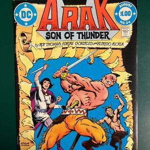 May include: A vintage comic book cover for "Arak, Son of Thunder" features a muscular warrior wielding a sword. The cover art includes other characters, text, and the DC Comics logo. The comic is labeled "August $1.00 No. 24" and "2nd Anniversary Spectacular!"