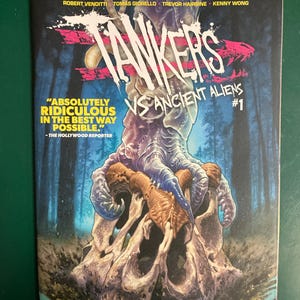 May include: A comic book titled Tankers vs Ancient Aliens #1 featuring a blue clawed hand gripping a large, weathered skull. The cover includes text credits for Robert Venditti, Tomás Giorello, Trevor Hairsine, and Kenny Wong, plus a quote.