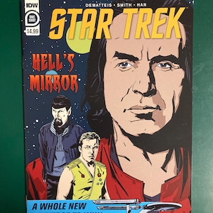 May include: A Star Trek comic book cover featuring a large portrait of a man in a red uniform. The title "STAR TREK" is in yellow, and the comic is titled "HELL'S MIRROR". The tagline reads "A WHOLE NEW UNIVERSE TO WIN!"