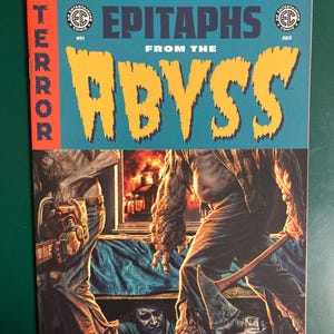 May include: A comic book cover titled "Epitaphs From The Abyss" with the word "Terror" in red. The cover art features a horror scene with figures wielding a chainsaw and an axe. The comic is marked "July".
