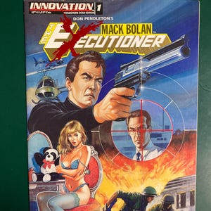 May include: Comic book cover featuring a man aiming a gun, with the title "The Executioner." The cover art includes a woman, soldiers, and a helicopter. The comic is a collector's gold edition.