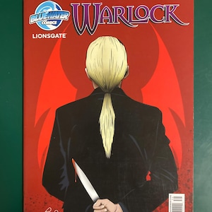 May include: A Warlock comic book issue 3 from BlueWater Comics and Lionsgate. The cover features a blonde figure in a black suit holding a knife behind their back against a red background. Text includes Warlock, Lyons, Bear, and Hunt.