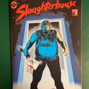 May include: A comic book cover for "Slaughterhouse" features a menacing figure in blue overalls holding a bloody cleaver. The title is in red, with the price $3.99 and issue number 1. The cover states "Official Adaptation of the 1987 Cult Classic."