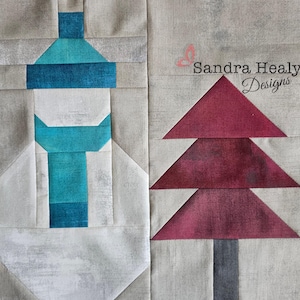 May include: A fabric quilt block featuring a teal and white lighthouse design and a burgundy tree. The lighthouse has a teal top and a white body. The tree has three burgundy triangular sections and a gray trunk. The background is a light gray.