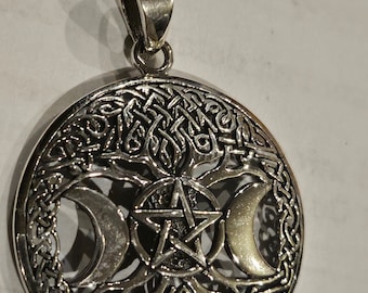 May include: A circular silver-toned pendant featuring an intricate tree design with interwoven branches. At the center, a five-pointed star is enclosed within a circle, flanked by two crescent moons on either side, all set against a detailed knotwork background.