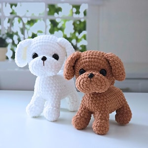 May include: Two crocheted stuffed dog toys. One is white and the other is brown.