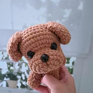 May include: A brown crocheted stuffed dog toy with black button eyes.
