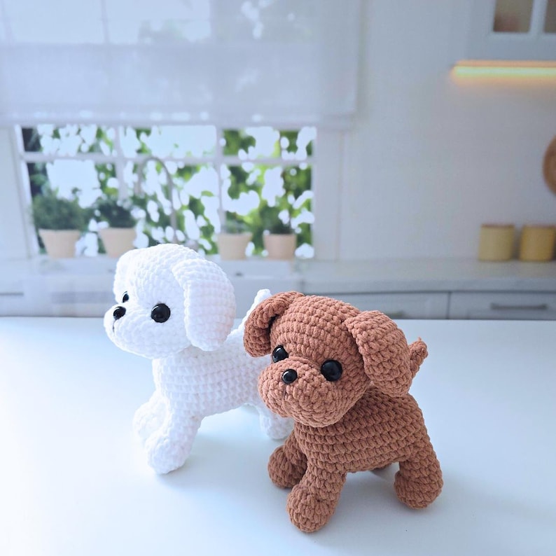 May include: Two crocheted stuffed dog toys. One is white and the other is brown.