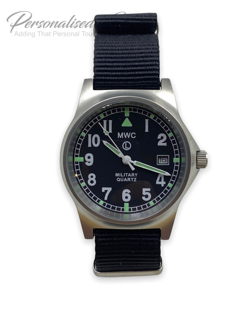 Puede incluir: Un reloj de estilo militar negro con caja plateada y correa de nylon negra. La esfera del reloj tiene n&uacute;meros blancos y una ventana de fecha. La esfera del reloj tambi&eacute;n tiene el texto "MWC" y "MILITARY QUARTZ".
