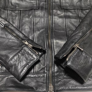 May include: Black leather jacket with a zipper closure and two zippered pockets on the sleeves.