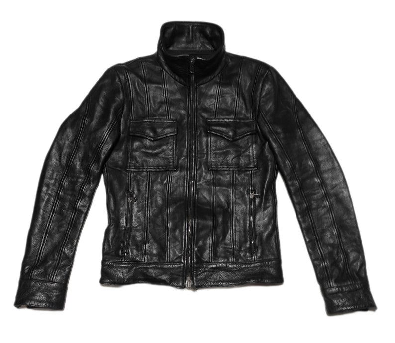 May include: A black leather jacket with a zipper closure and two large flap pockets. The jacket has vertical stitching details throughout.
