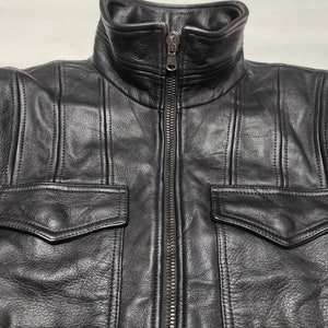 May include: A black leather jacket with a zipper closure and two large flap pockets on the front.