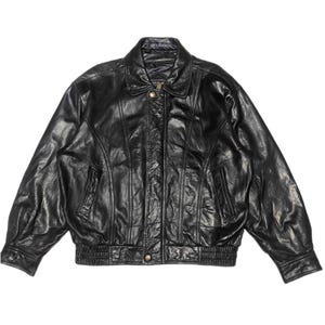 May include: Black leather jacket with a classic bomber style. Features a collared neckline, front zipper closure, and elasticized cuffs and waistband. The jacket has a quilted lining and two front pockets. A timeless outerwear piece.
